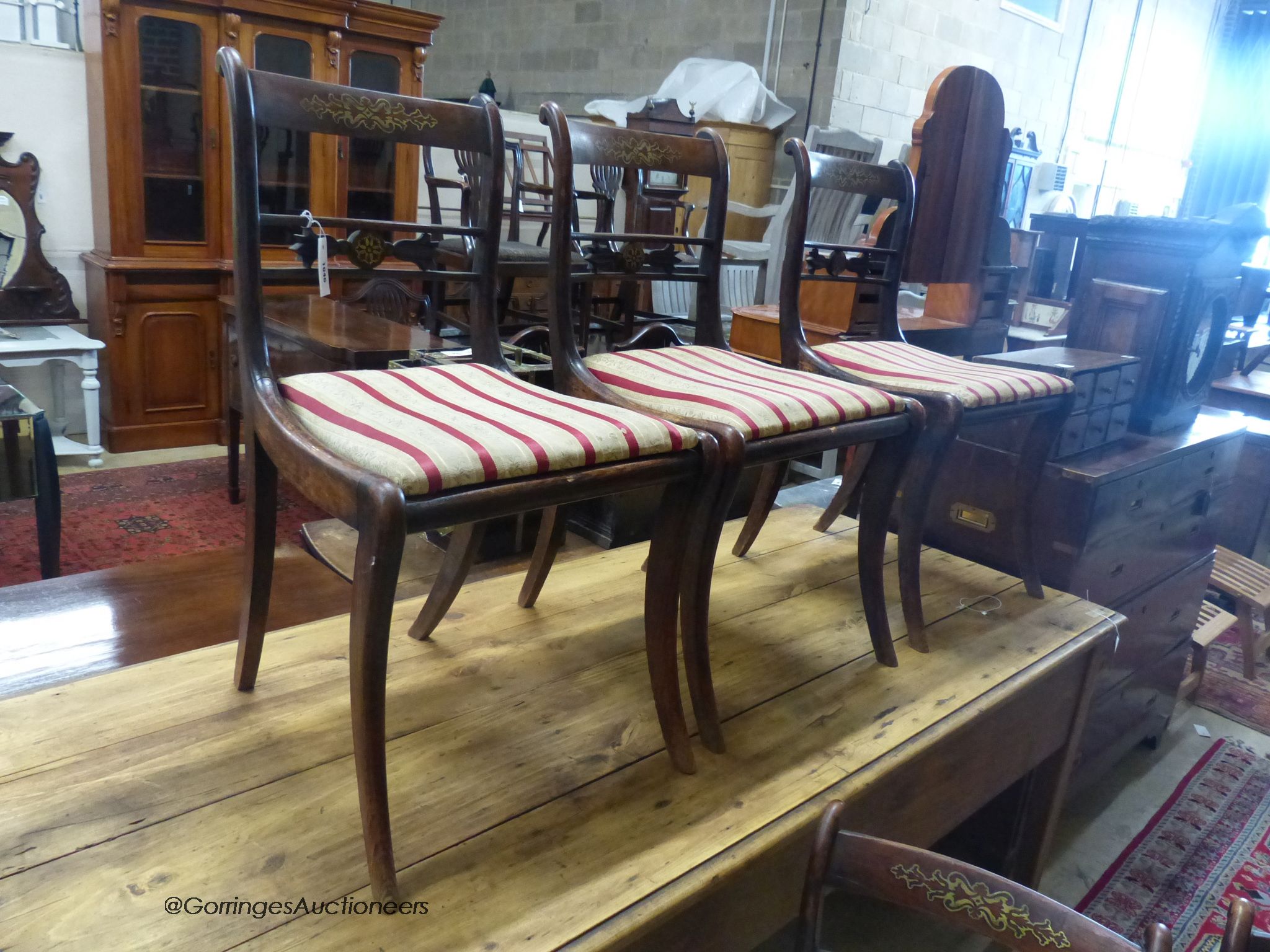 A set of five Regency brass inlaid simulated rosewood cane seated dining chairs